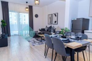a dining room and living room with a table and chairs at Bloomfields Elegant 1br In Waters Edge Yas Island in Yas Island