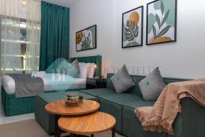 un salon avec un canapé vert et un lit dans l'établissement Bloomfields Grandeur Stu In Oasis Masdar City, à Al Qurayyah 20 autres photos