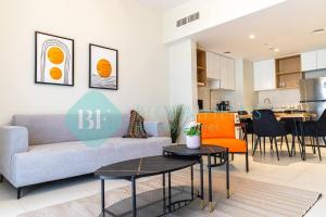 a living room with a couch and a table at Bloomfields Stylish 1br In Reflections Al Reem in Mushayrib