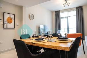 a dining room with a wooden table and chairs at Bloomfields Stylish 1br In Reflections Al Reem in Mushayrib +10 photos