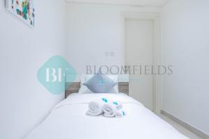 a bedroom with a bed with two towels on it at Bloomfields Metropolitan 3br In Bridges in Abu Dhabi