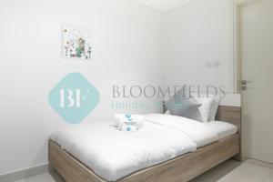 a bedroom with a bed with a sign that reads bloometts holiday at Bloomfields Metropolitan 3br In Bridges in Abu Dhabi