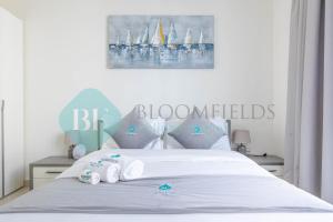 a bedroom with a bed with two towels on it at Bloomfields Metropolitan 3br In Bridges in Abu Dhabi