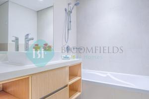 a bathroom with a sink and a bath tub at Bloomfields Metropolitan 3br In Bridges in Abu Dhabi +18 photos