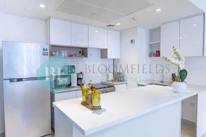 a kitchen with white cabinets and a white counter top at Bloomfields Metropolitan 3br In Bridges in Abu Dhabi