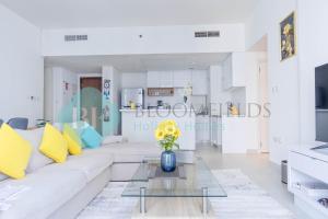 a living room with a white couch and a glass table at Bloomfields Metropolitan 3br In Bridges in Abu Dhabi