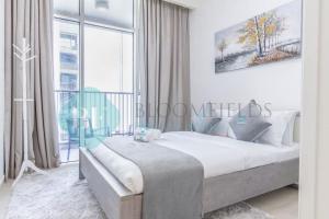 a bedroom with a large bed and a large window at Bloomfields Metropolitan 3br In Bridges in Abu Dhabi