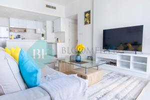 a living room with a couch and a tv at Bloomfields Metropolitan 3br In Bridges in Abu Dhabi