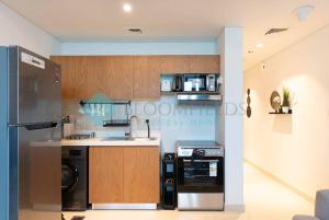 a kitchen with a refrigerator and a dishwasher at Bloomfields Premium Stu Canal View Julphar Tower in Abu Dhabi