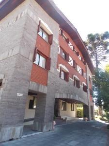 um grande edifício de tijolos com uma fachada vermelha em Apart-hotel em Gramado, padrão 4 estrelas, no centro em Gramado