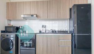 a kitchen with a stove and a sink and a refrigerator at Bloomfields Cozy Stu In The View Raha Beach in Abu Dhabi