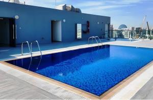a swimming pool on the roof of a building at Bloomfields Cozy Stu In The View Raha Beach in Abu Dhabi