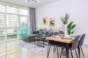 a white living room with a table and chairs at Bloomfields Hidden Gem 1br In Elyacout Tower in Abu Dhabi