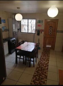 a kitchen with a wooden table in a room at Hostal CacTus in Coquimbo +20 photos