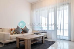 Abu Dhabi IntlBloomfields Mesmerizing 1br In Oasis Masdar City的客厅里有一张沙发和一张咖啡桌。