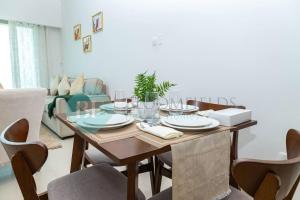 MushayribにあるBloomfields 1br Amazing Sky View At Gate Towerの木製のテーブルと椅子のあるダイニングルーム