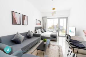 una sala de estar con un sofá y una cama en Bloomfields Premium Stu In Oasis Masdar City, en Abu Dhabi Intl