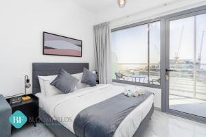Un dormitorio con una cama grande y una ventana grande en Bloomfields Premium Stu In Oasis Masdar City, en Abu Dhabi Intl