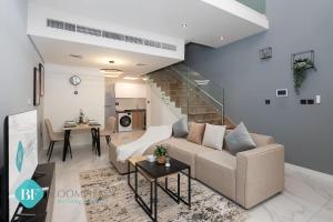 a living room with a couch and a table at Bloomfields Premium 1br Duplex In Rukan in Nadd Shubayḩ