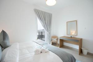 Schlafzimmer mit einem Bett, einem Schreibtisch und einem Spiegel in der Unterkunft Bloomfields Iconic 1br Waters Edge Yas Island in Abu Dhabi