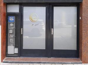 a door with a sign on it with a car reflected in it at hena apart 1 in Esquel +4 photos