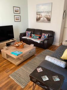 Beach Hideaway في ليثام سانت أنيه: غرفة معيشة مع أريكة وطاولة قهوة