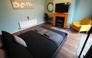 レイランドにあるDetached Homestay - Super, King & Double Rooms - Leyland, Preston, Chorley, Lancashireのベッドルーム(ベッド1台、テレビ、椅子付) +40枚の写真