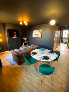 a living room with a table and a couch at Gatsby Room - Élégance et Intimité des Années 20 ! in Villeneuve-sur-Lot