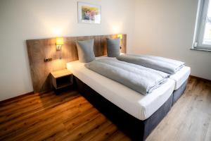 a bedroom with a large bed with a wooden headboard at Boardinghouse Victory in Augsburg