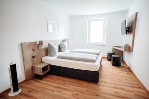 a bedroom with a bed and a television in it at Boardinghouse Victory in Augsburg