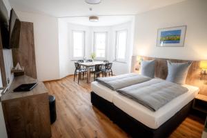 a bedroom with a large bed and a table at Boardinghouse Victory in Augsburg