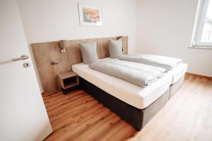 a bed in a bedroom with a wooden floor at Boardinghouse Victory in Augsburg +62 photos