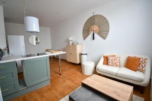 een keuken en woonkamer met een bank en een tafel bij Suite Belleville in Saint-Dizier