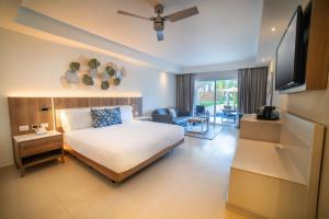 a hotel room with a bed and a television at Royalton Hideaway Punta Cana, An Autograph Collection All-Inclusive Resort & Casino - Adults Only in Punta Cana