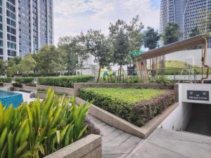 un parc avec une piscine, des plantes et des bâtiments dans l'établissement Sunway Greenfield Residence with Amazing Pool Facilities, à Petaling Jaya