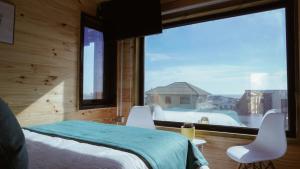 una camera da letto con un letto e una grande finestra di Pichilemu Apart Hotel a Pichilemu