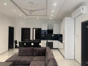 a living room with a couch and a kitchen at Golden Hayat Suites in East Legon