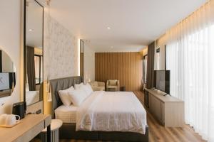 a hotel room with a bed and a television at Zeen Sky Resort in Ban Noi