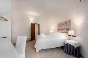 a bedroom with a bed and a table with a lamp at Hotel Villa Mediterranea in Noto Marina