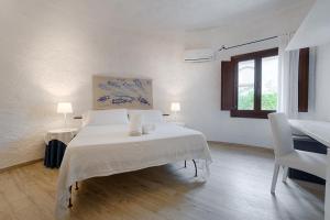 a white bedroom with a bed and a window at Hotel Villa Mediterranea in Noto Marina