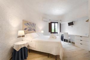 a bedroom with a bed and a table and a kitchen at Hotel Villa Mediterranea in Noto Marina