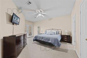 Un dormitorio con una cama y un ventilador de techo. en Legacy Villa 2601, en Gulfport