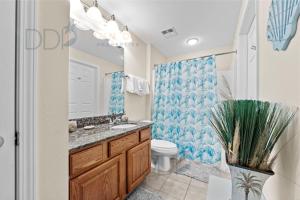 a bathroom with a toilet and a sink and a mirror at Legacy Tower Two 1202 Deluxe in Gulfport +21 photos
