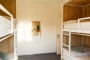 a room with four bunk beds and a window at The Lighthouse Hostel in Sagres