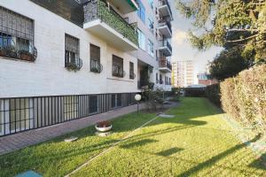 een tuin met een gazon voor een gebouw bij PrimoPiano - Cucchi in Milaan