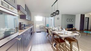eine Küche mit einem langen Tisch und Stühlen in der Unterkunft Grain de Vie - Belle maison proche plage in Saint-Gilles-Croix-de-Vie + 19 Fotos