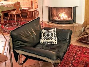 a leather chair with a pillow in front of a fireplace at Holiday Home Midat soleil by Interhome in Verbier +29 photos