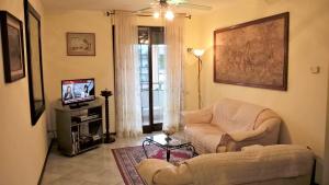 a living room with a couch and a tv at Assisi Casa degli Angeli in Assisi