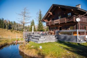 domek z bali ze stawem przed nim w obiekcie Marktlhütte w mieście Hochrindl