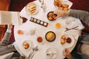 two people sitting at a white table with breakfast foods at Le Castel Marie Louise in La Baule